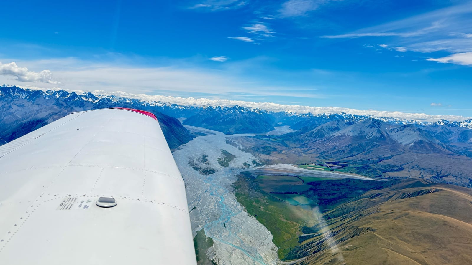 View across a mountain valley from a light aircraft in flight.