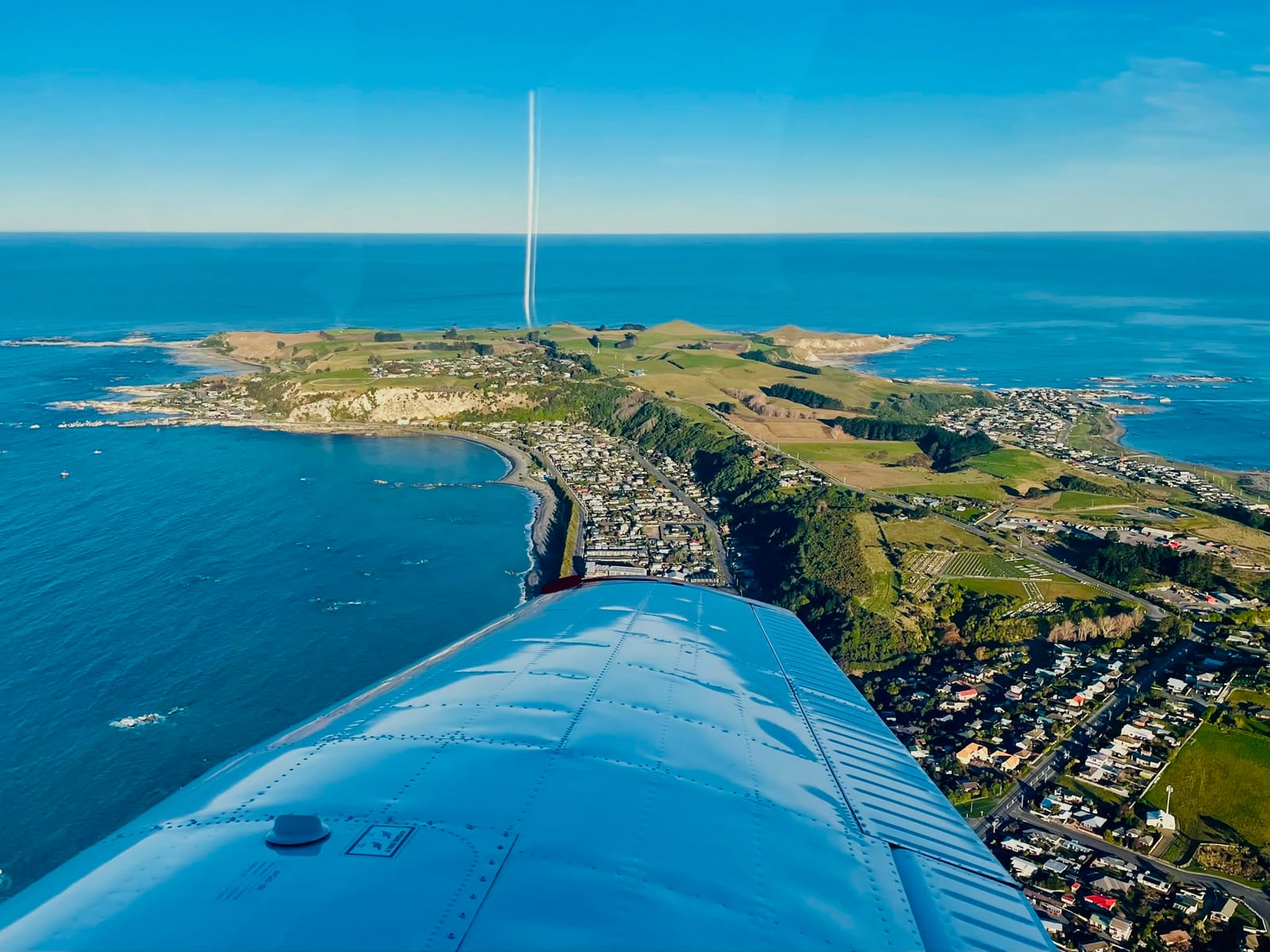View over a New Zealand coastal town from a light aircraft in flight.